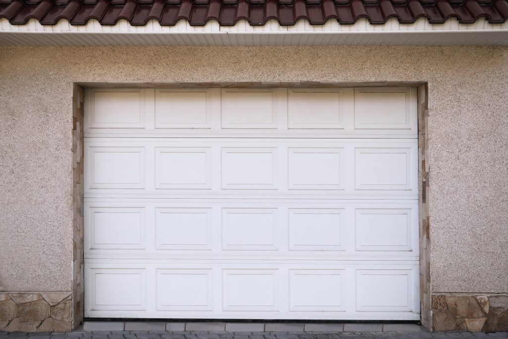 white modern sectional garage doors on building